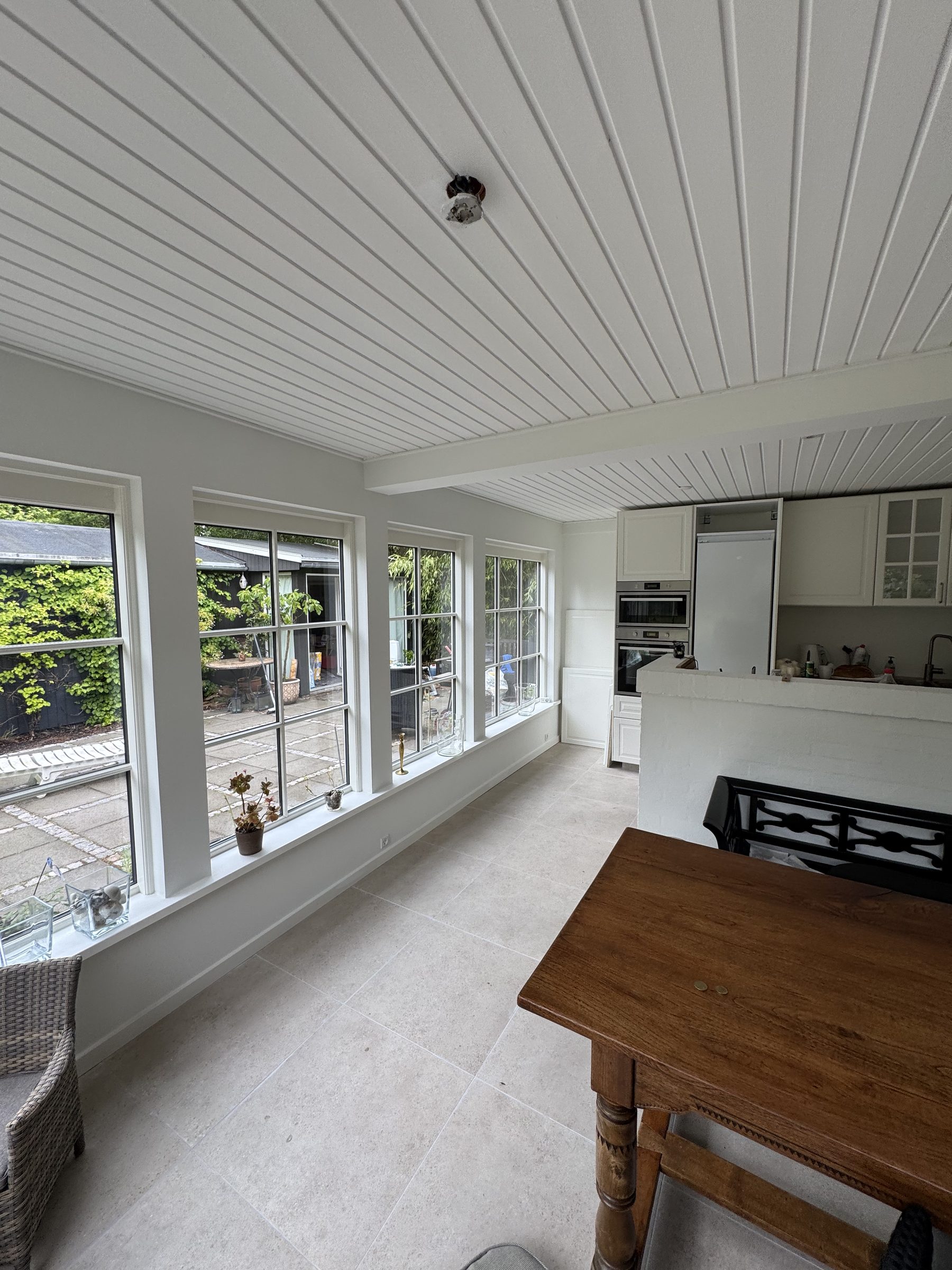 Færdig glasveranda med køkken og udsigt til have