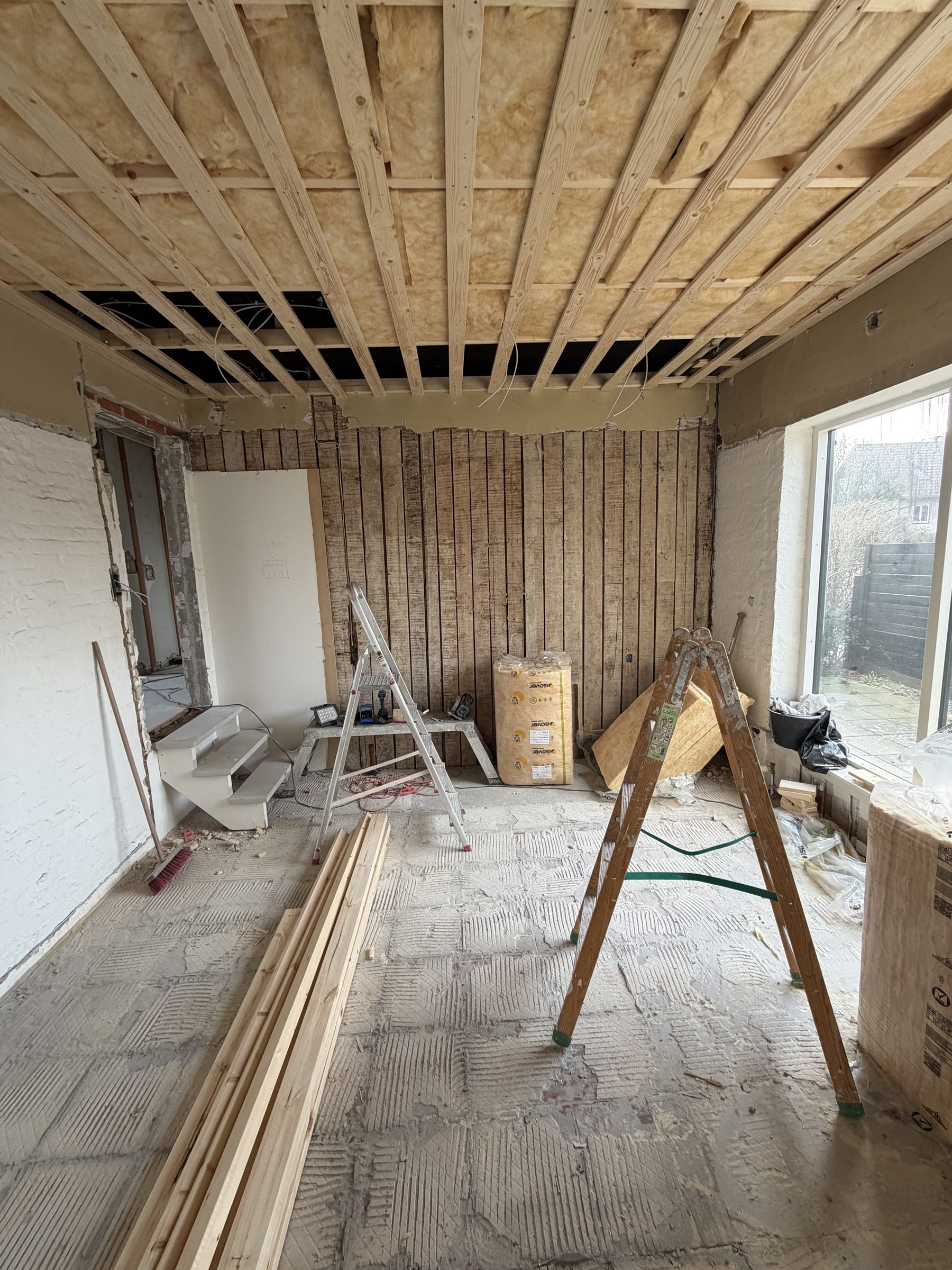 Rum under totalrenovering med åben loftkonstruktion og isolering