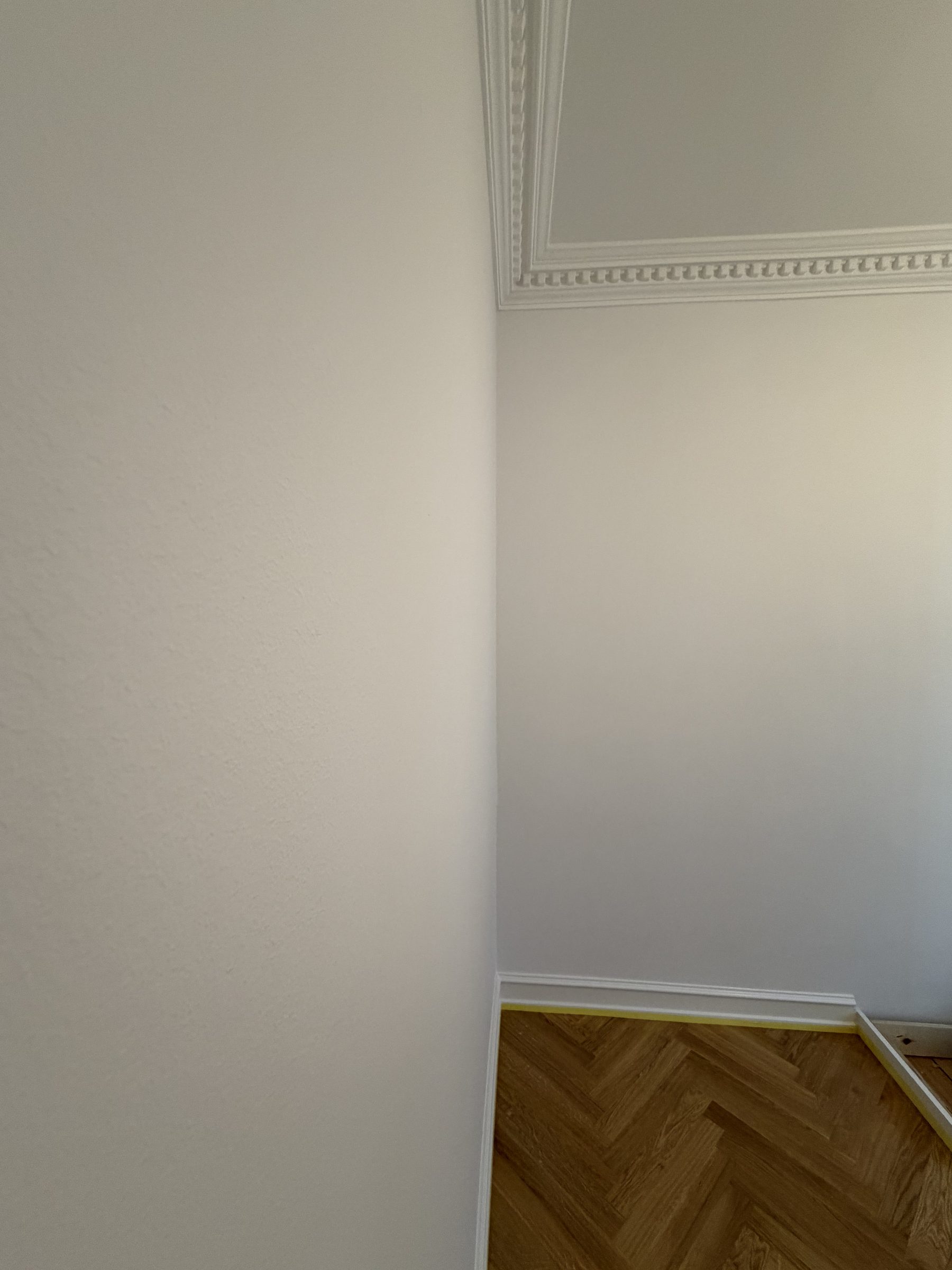 Hjørne med stuk, hvide vægge og sildebensparket